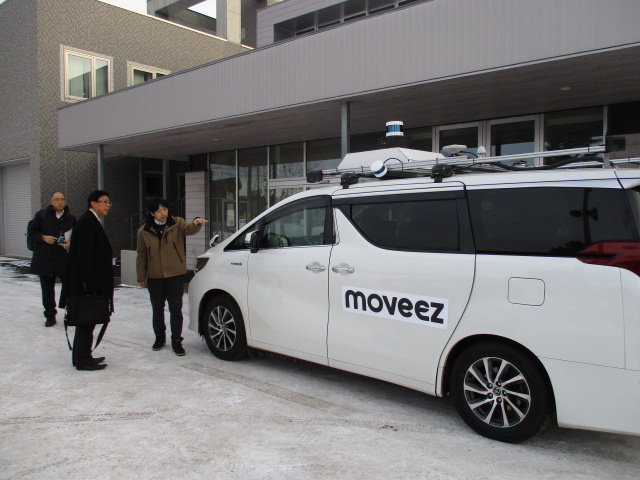 開発企業関係者から自動運転タクシーについて説明を受けている様子