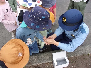 警察官が子どもたちにひまわりの種を配っているようす