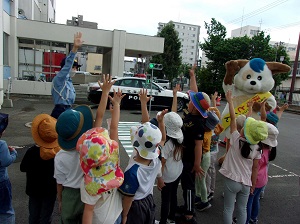 みんなで手を挙げて横断歩道を渡る練習をしているようす
