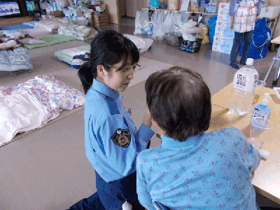 避難所で被災者から要望を聞く女性警察官の写真